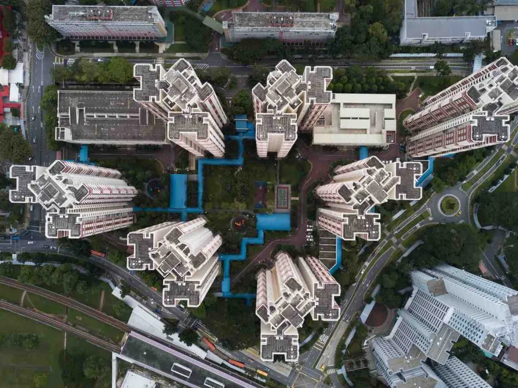 Singapore Infrastructure Connectivity Projects: Aerial view of a complex with multiple residential towers arranged in a star pattern, surrounded by greenery and roads.