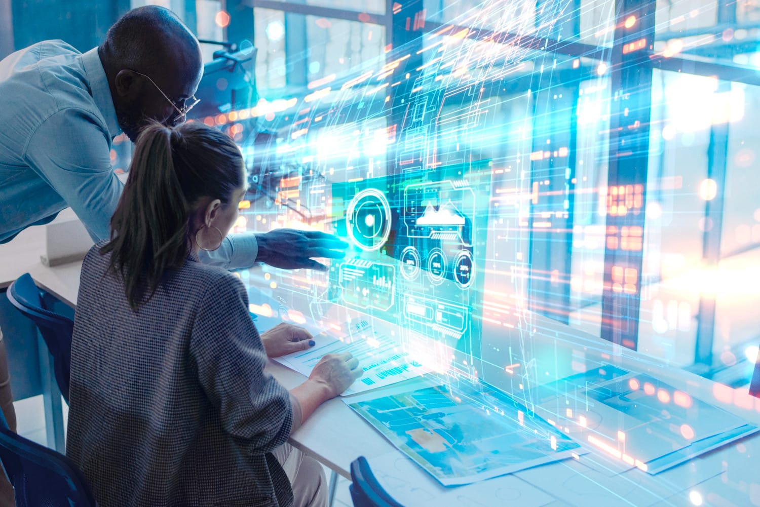 Digital Surveillance: A professional collaborates with a colleague at a digital workspace, analyzing holographic data projections on a computer screen.
