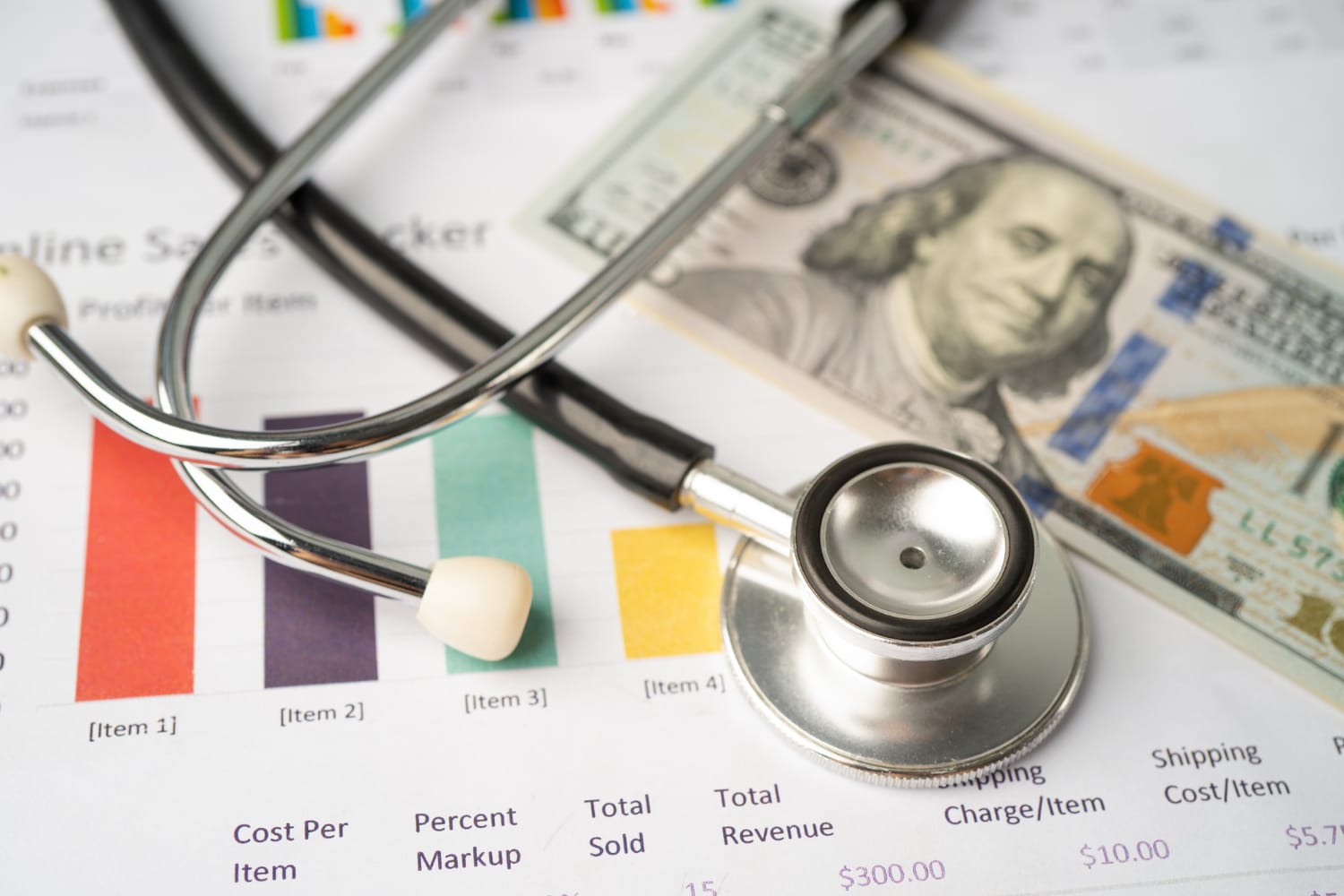 A stethoscope rests on printed financial documents next to a hundred-dollar bill, illustrating the Middle East Healthcare Investment and the intersection of healthcare and finance.