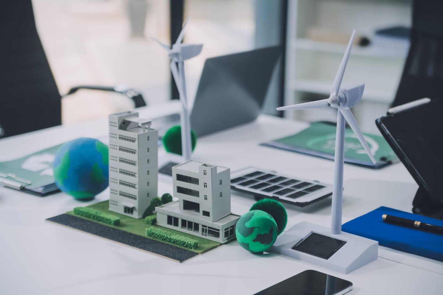 Malaysia Energy-Efficient Buildings: A tabletop display featuring miniature buildings, wind turbines, and globes, symbolizing sustainable architecture and energy solutions.