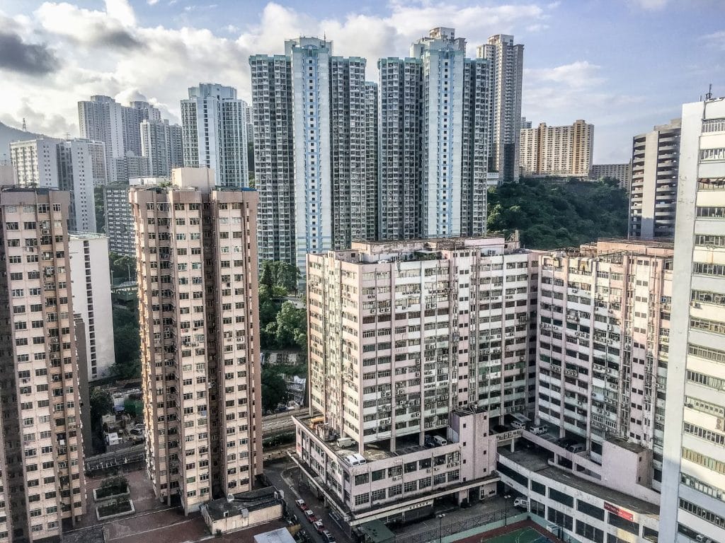 Singapore Real Estate Market Insights: View of a dense urban landscape in Singapore, featuring tall residential buildings amid a backdrop of mountains and cloudy skies.