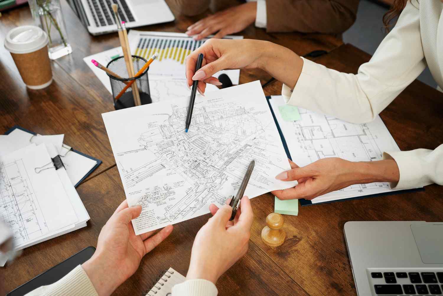 Digital Urban Planning Tools: A detailed map is analyzed during a collaborative meeting, surrounded by documents, a laptop, and office supplies.